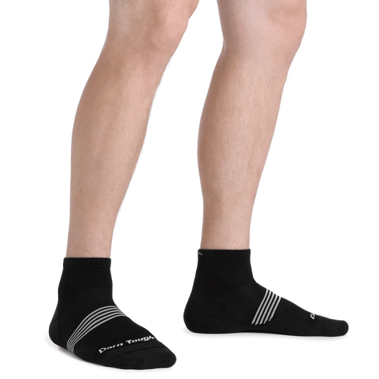Black socks with white stripes worn by a person on a white background