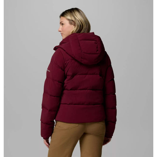 Person wearing a maroon puffer jacket on a gray background