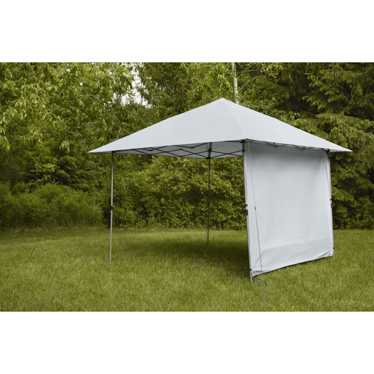 Outdoor canopy tent with side panel in a grassy area with trees