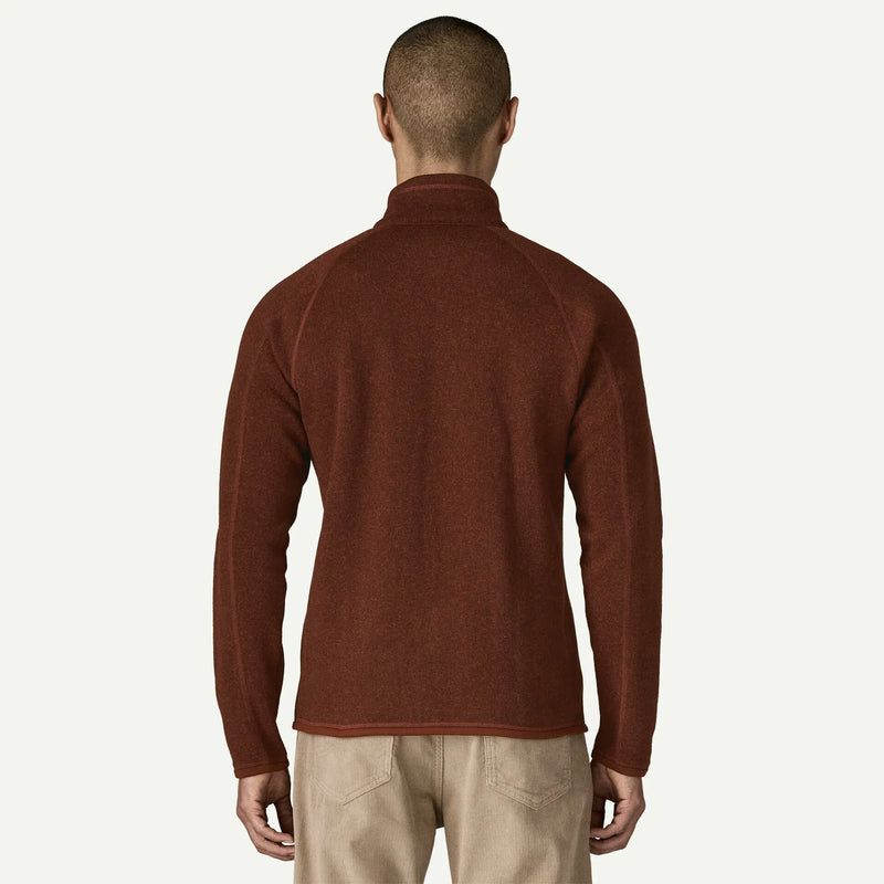 Load image into Gallery viewer, A man viewed from the back wearing a rust-brown long-sleeve quarter-zip fleece sweater and beige pants, set against a plain off-white background.
