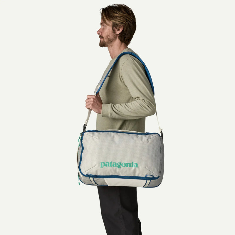 Load image into Gallery viewer, Man carrying a white Patagonia bag with a blue trim