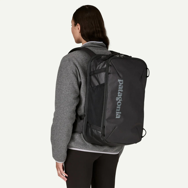Load image into Gallery viewer, Person wearing a black Patagonia backpack on a white background