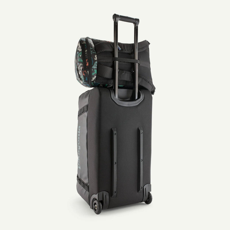 Load image into Gallery viewer, Black rolling suitcase with a camouflage-patterned bag on top against a white background