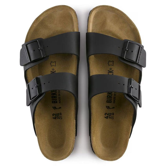 Pair of brown sandals with black straps on a white background