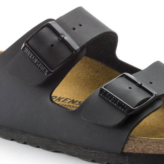 Black Birkenstock sandals with a buckle on a white background
