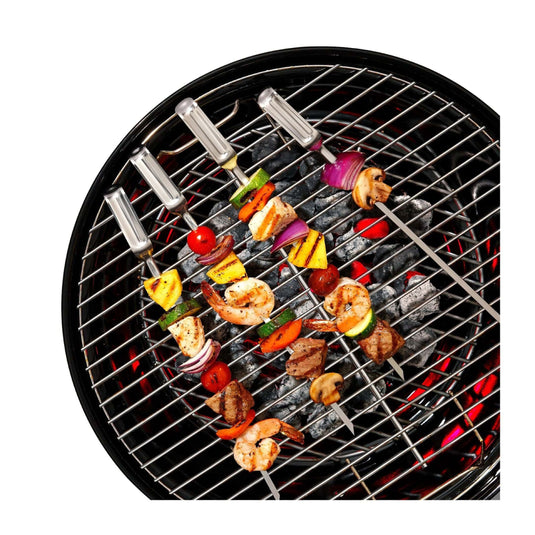 Barbecue grill with skewers of vegetables and shrimp on a white background