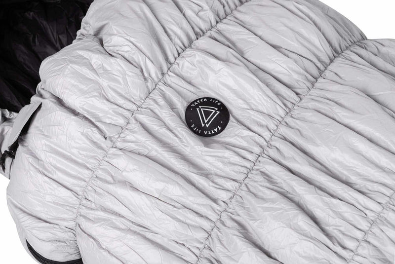 Load image into Gallery viewer, Grey goose down sleeping bag with Yatta Life logo, lightweight and weather-resistant for outdoor adventures.