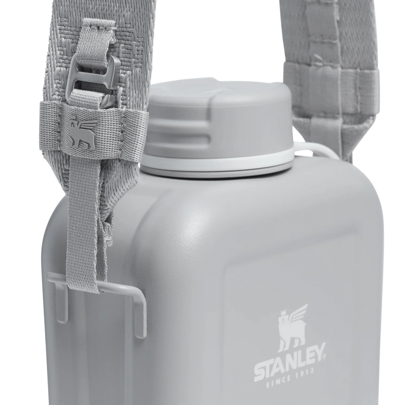 Load image into Gallery viewer, Gray water bottle with a strap and Stanley logo on a white background
