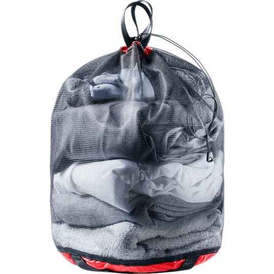 Drawstring bag filled with folded clothes on a white background