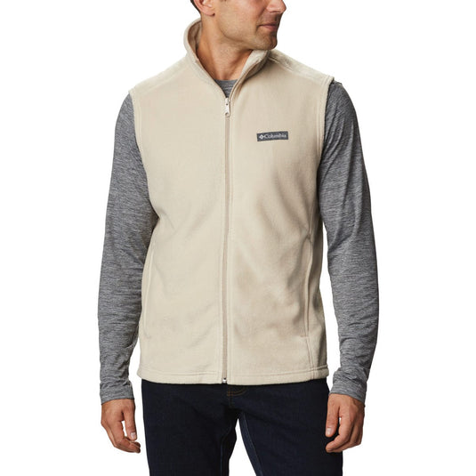 Man wearing a beige fleece vest with Columbia logo on a white background