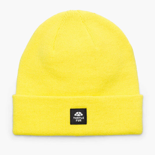 Yellow beanie with a black label on a light gray background