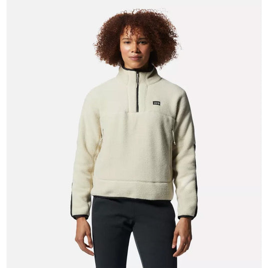 Person wearing a beige fleece pullover with a brand logo on a white background