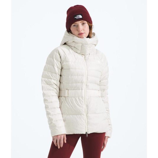 Person wearing a white puffer jacket and red beanie with The North Face logo on a white background