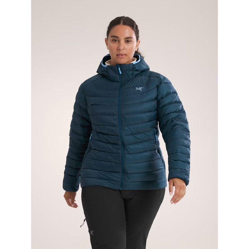 Load image into Gallery viewer, Person wearing a blue puffer jacket with a brand logo on a light gray background