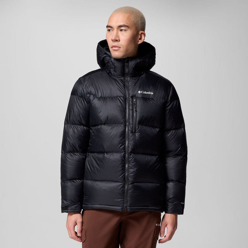 Load image into Gallery viewer, Man wearing a black puffer jacket with Columbia logo on a gray background