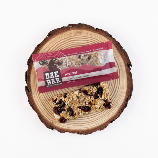 Dak Bar squirrel snack on a wooden log with packaging