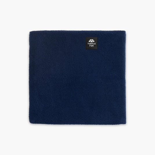 Navy blue neck warmer with a brand label on a light gray background