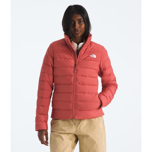 Person wearing a red puffer jacket with a brand logo on a white background