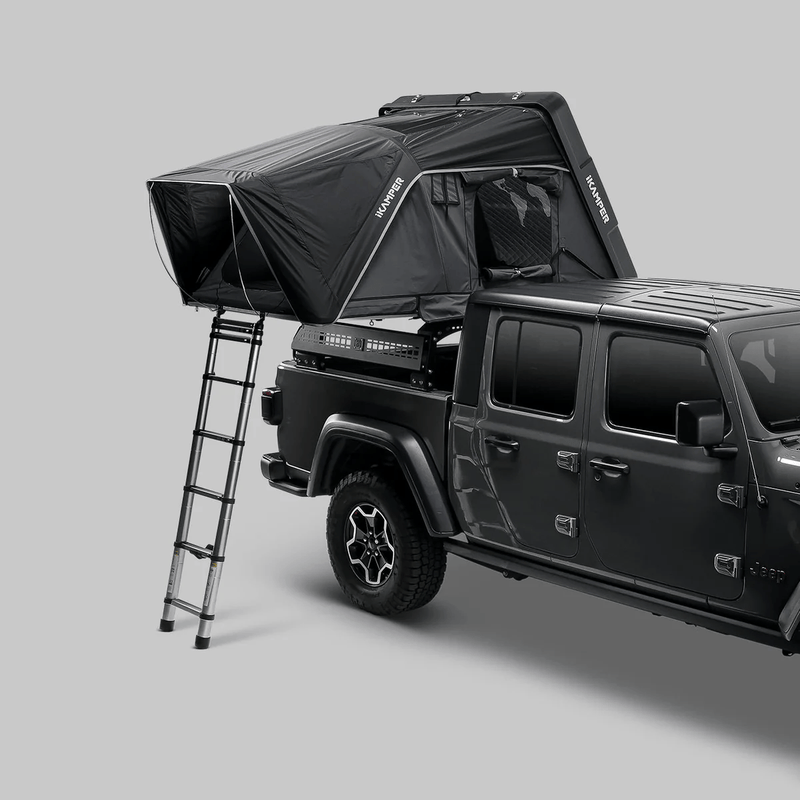Load image into Gallery viewer, Black rooftop tent on a Jeep Wrangler against a gray background