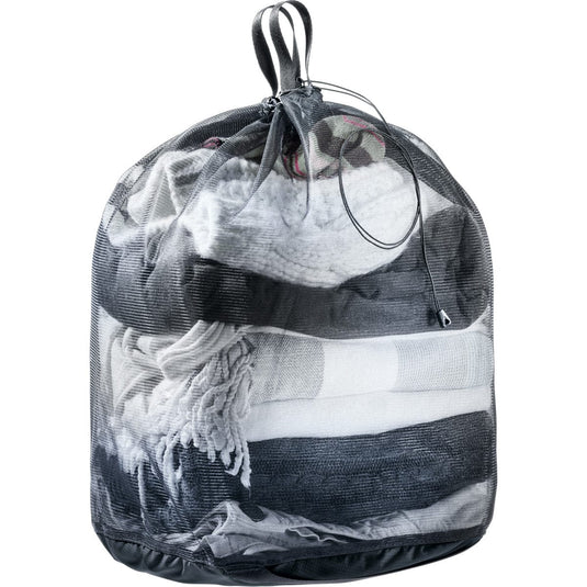 Mesh laundry bag filled with clothes on a white background