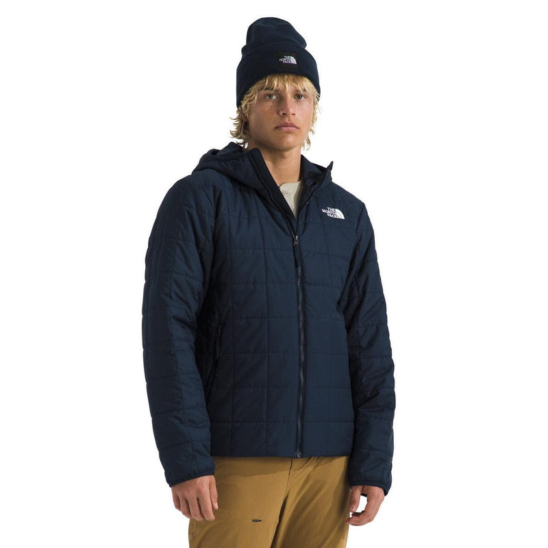 Load image into Gallery viewer, Person wearing a navy blue jacket and beanie with The North Face logo on a white background