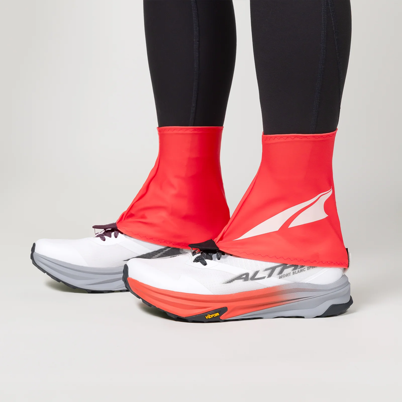 Load image into Gallery viewer, Red shoe covers over white running shoes with a visible brand logo on a neutral background