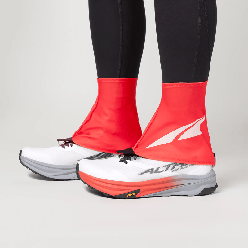 Load image into Gallery viewer, Red shoe covers over white running shoes with a visible brand logo on a neutral background