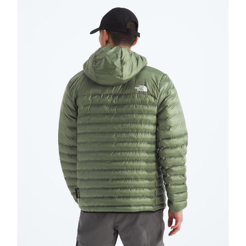 Load image into Gallery viewer, Person wearing a green puffer jacket with a brand logo on a white background