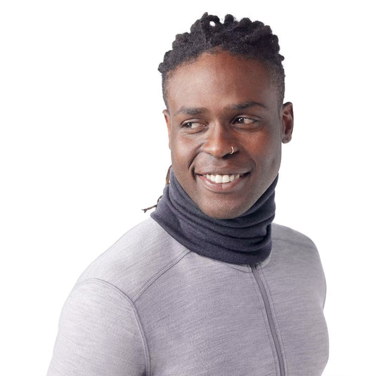 Man wearing a gray long-sleeve shirt and dark gray neck gaiter on a white background