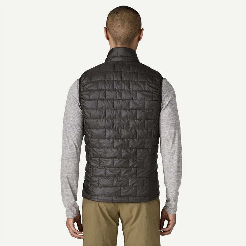 Load image into Gallery viewer, Person wearing a black quilted vest over a gray long-sleeve shirt on a white background