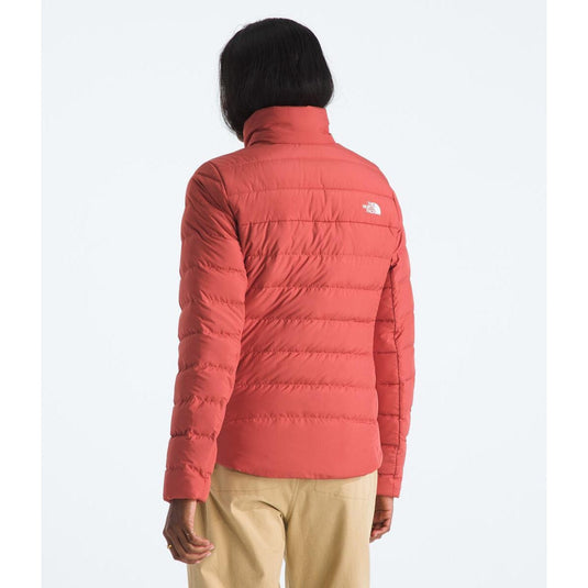 Person wearing a red puffer jacket with a visible brand logo on a white background
