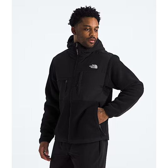 Man wearing a black jacket with a brand logo on a white background