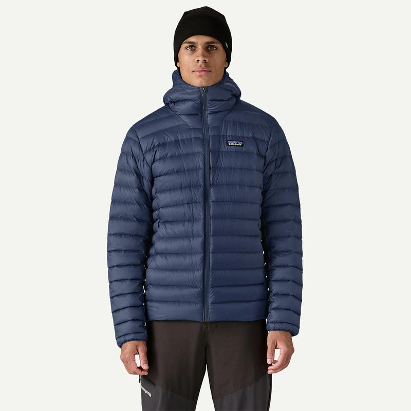 Load image into Gallery viewer, Person wearing a blue puffer jacket with a brand logo on a white background