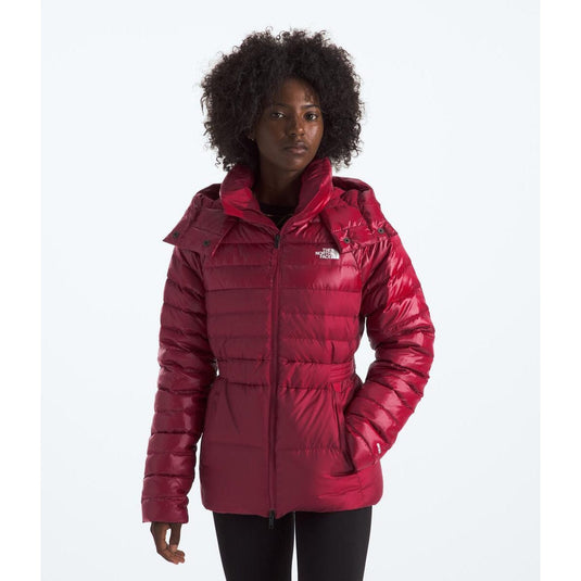 Person wearing a red puffer jacket with a brand logo on a white background