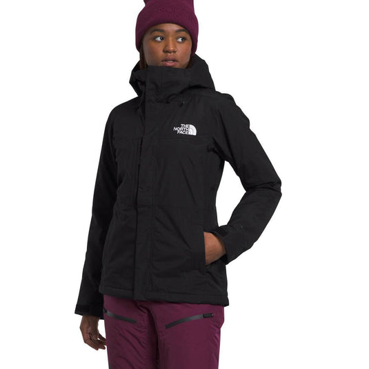 Person wearing a black The North Face jacket and maroon beanie and pants on a white background