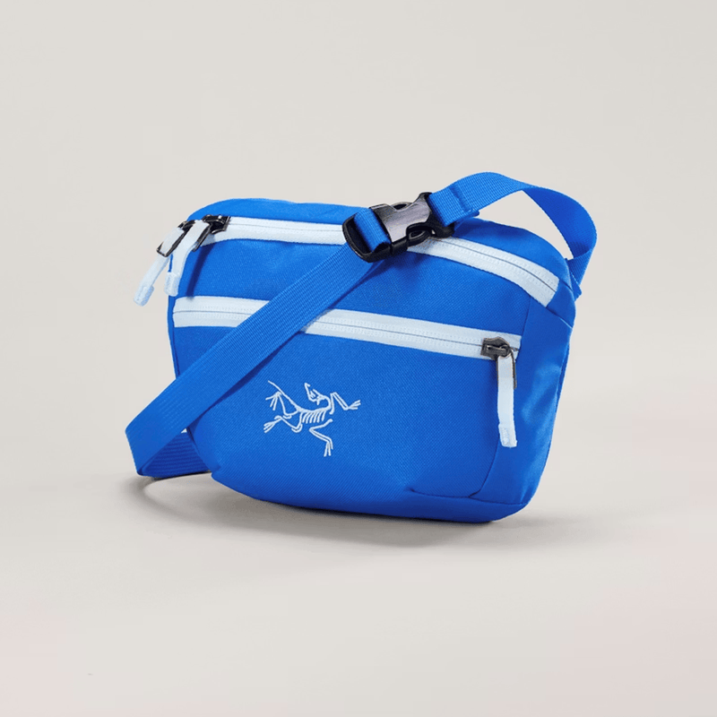 Load image into Gallery viewer, Blue crossbody bag with a logo on a beige background