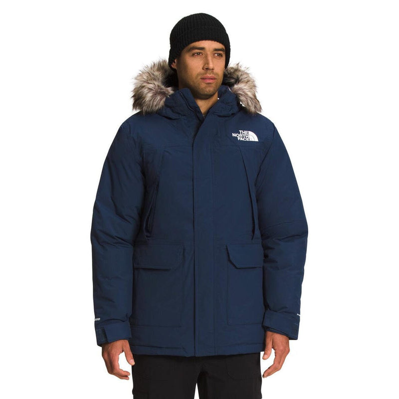 Load image into Gallery viewer, Man wearing a blue winter jacket with fur-lined hood on a white background