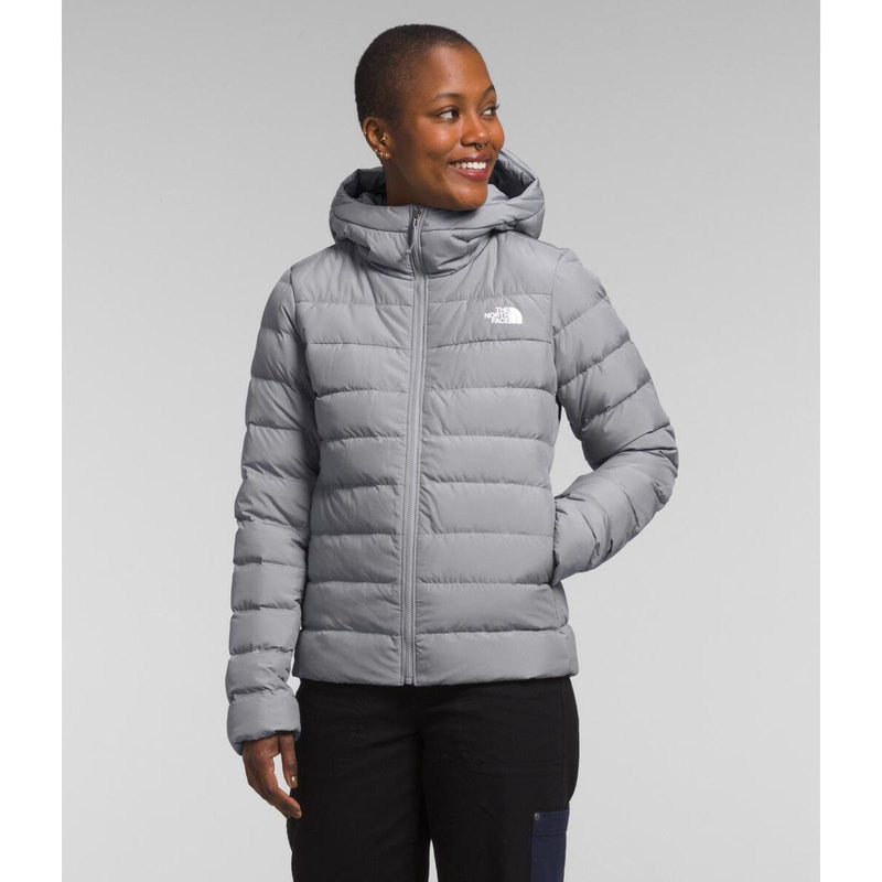 Load image into Gallery viewer, Woman wearing a gray puffer jacket with a visible brand logo on a light gray background