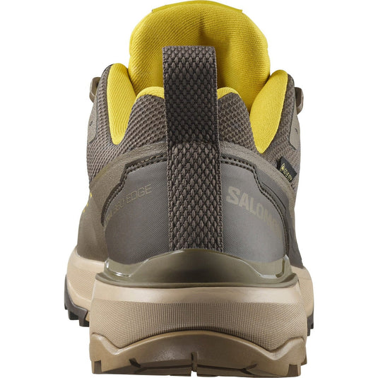 Back view of a gray hiking shoe with yellow accents and Salomon branding.