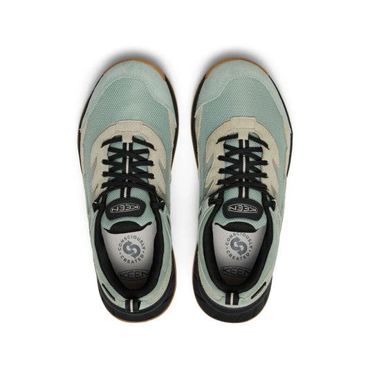 Pair of green athletic shoes with black soles on a white background