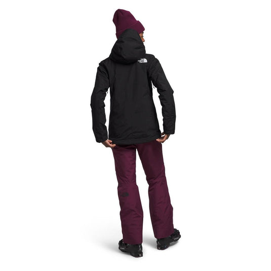 Person wearing a black jacket and purple pants with a white background