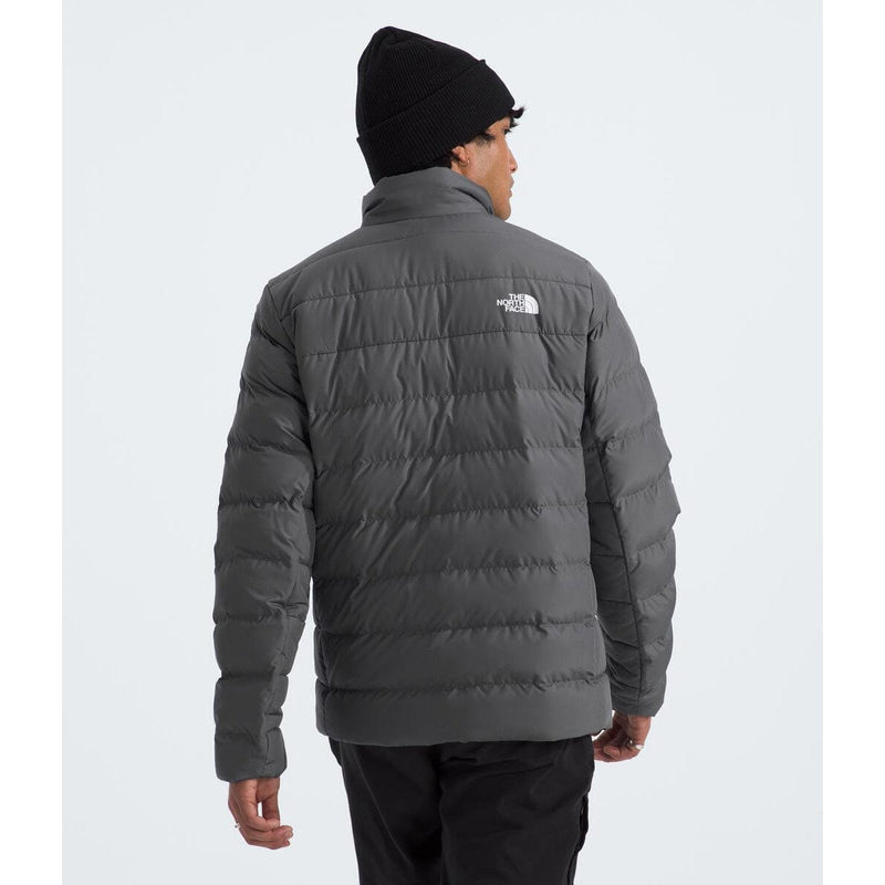 Load image into Gallery viewer, Person wearing a gray puffer jacket with a brand logo on a white background