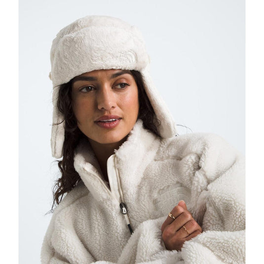 Person wearing a white fleece hooded poncho against a white background