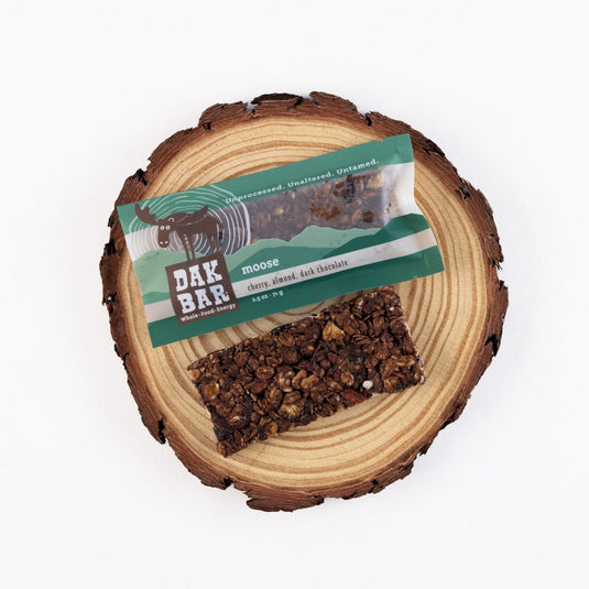 Dak Bar moose snack on a wooden log with a clear label
