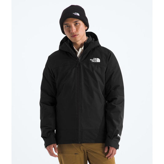 Person wearing a black jacket with a brand logo on a white background