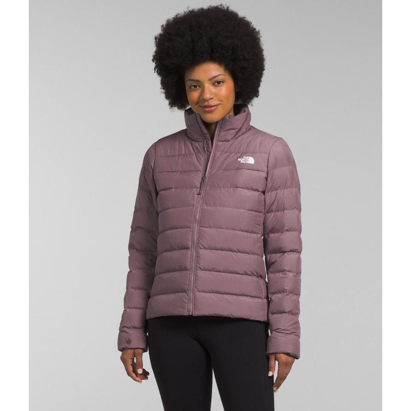 Load image into Gallery viewer, Woman wearing a purple puffer jacket with a brand logo on a gray background