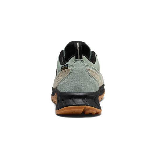 Green and black sneaker with brown sole on a white background