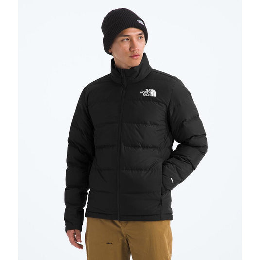 Person wearing a black puffer jacket with a brand logo on a white background