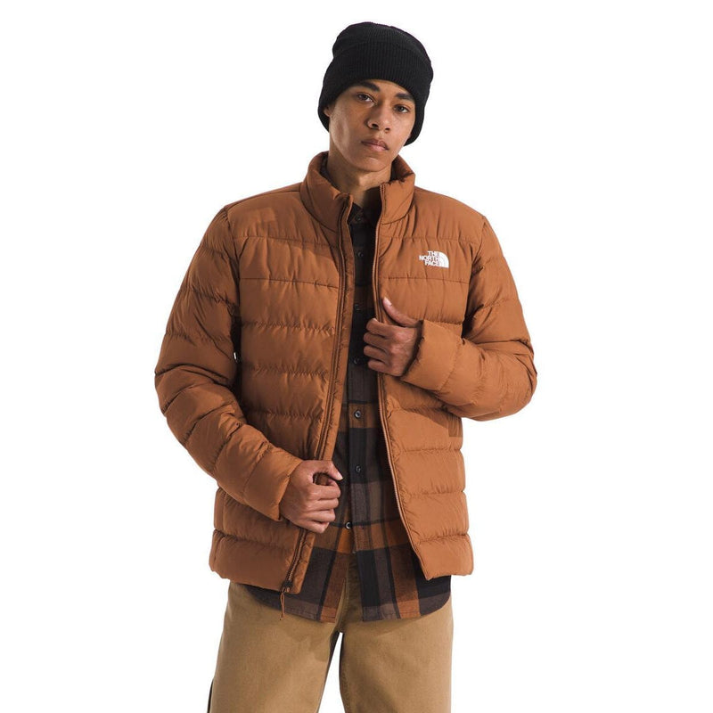 Load image into Gallery viewer, Person wearing a brown puffer jacket with The North Face logo on a white background