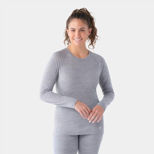 Woman wearing a gray long-sleeve athletic shirt on a white background